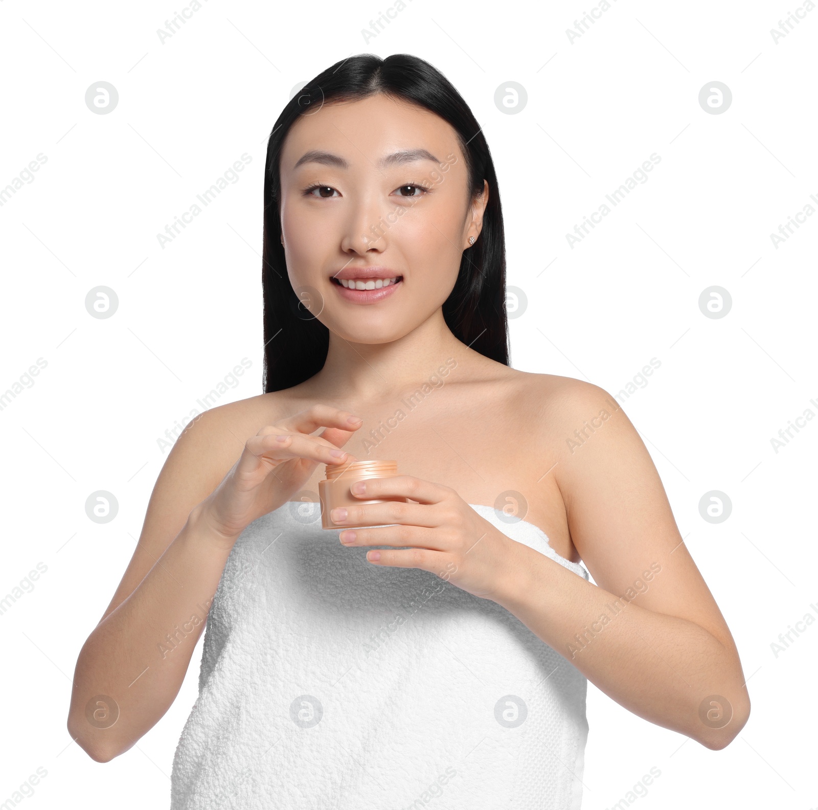 Photo of Beautiful young Asian woman with jar of body cream on white background