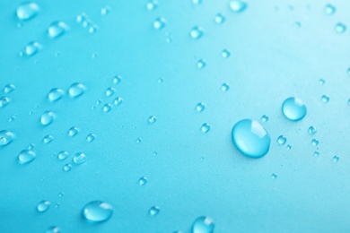 Many clean water drops on color background