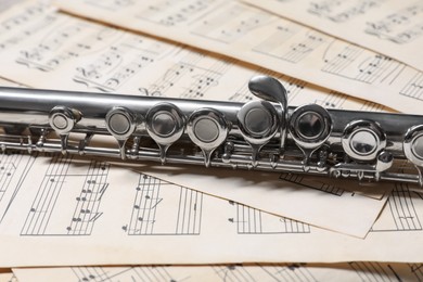 Photo of Classical flute on sheets with musical notes, closeup