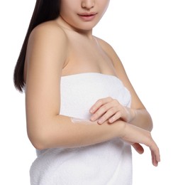 Young woman applying body cream onto arm on white background, closeup