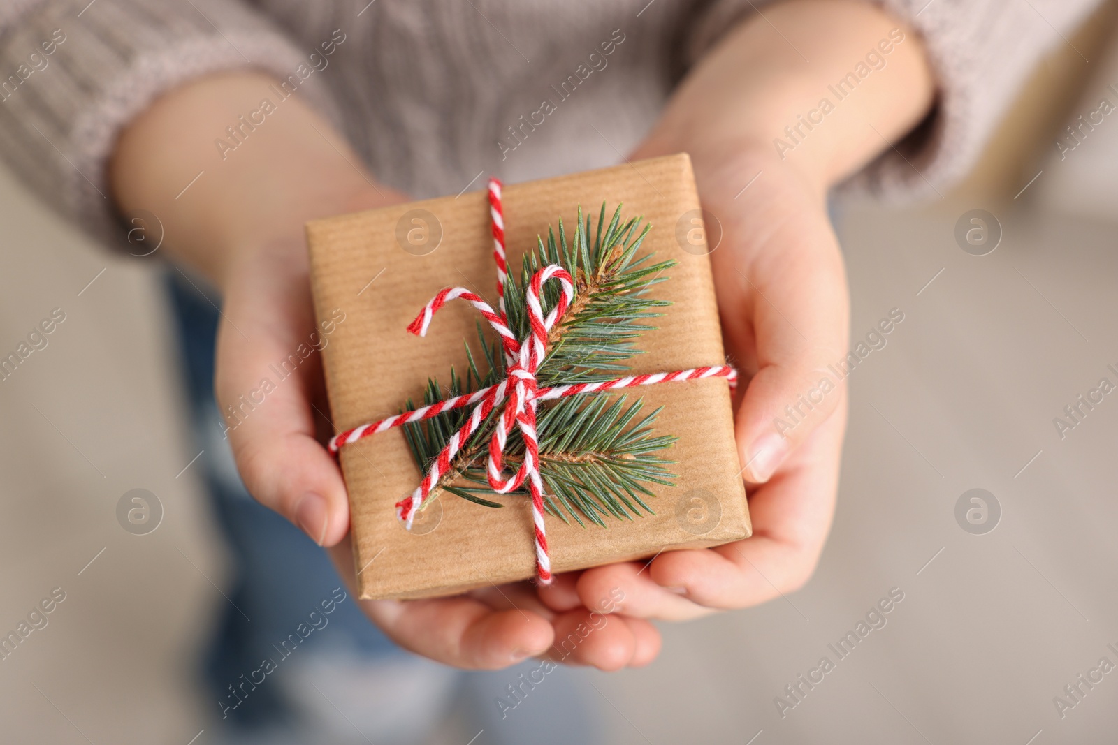 Photo of Little child holding decorated box, closeup. Christmas gift