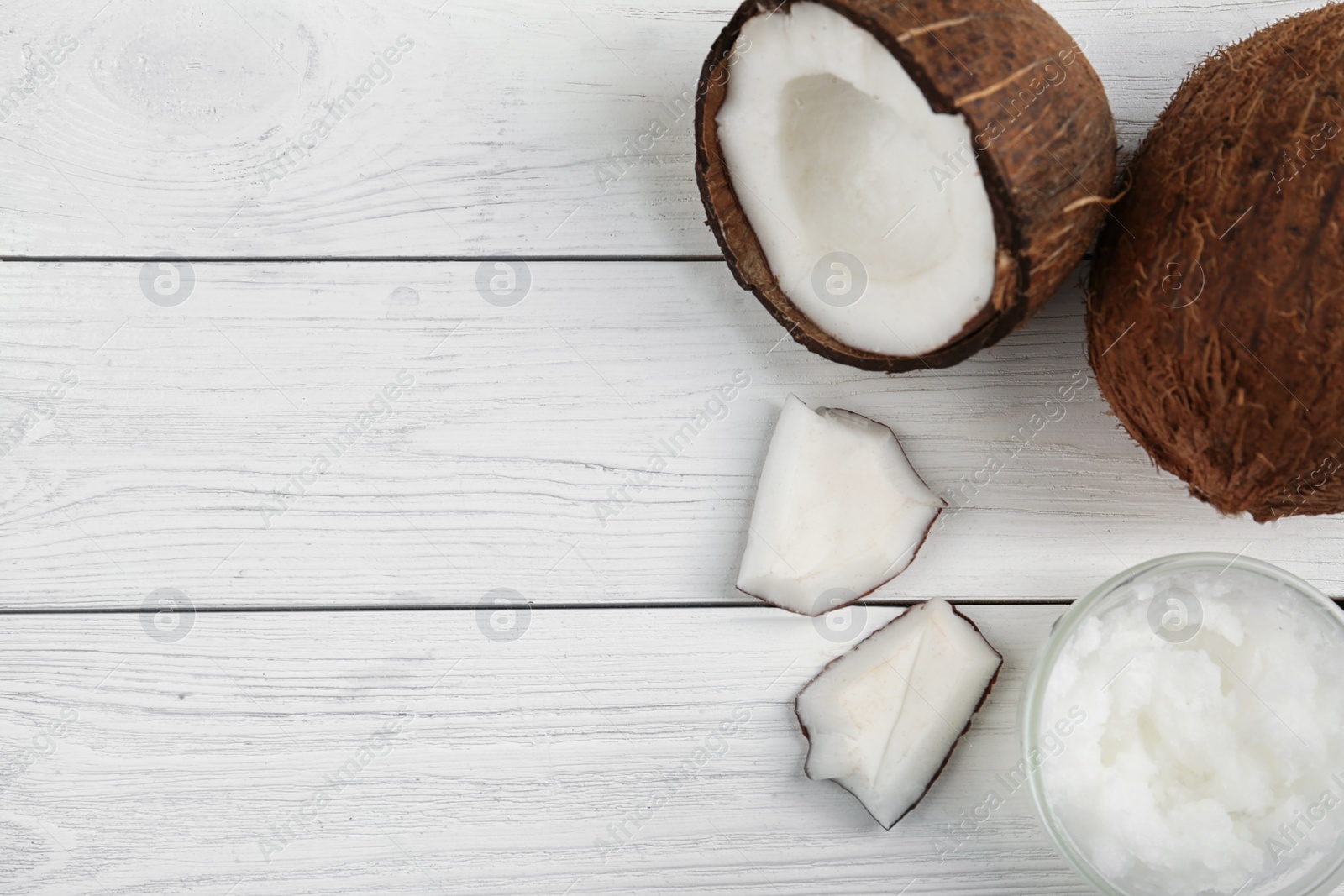 Photo of Flat lay composition with coconut oil on white wooden table, space for text. Cooking ingredients