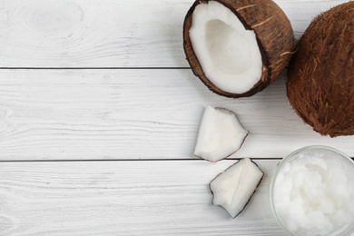 Photo of Flat lay composition with coconut oil on white wooden table, space for text. Cooking ingredients