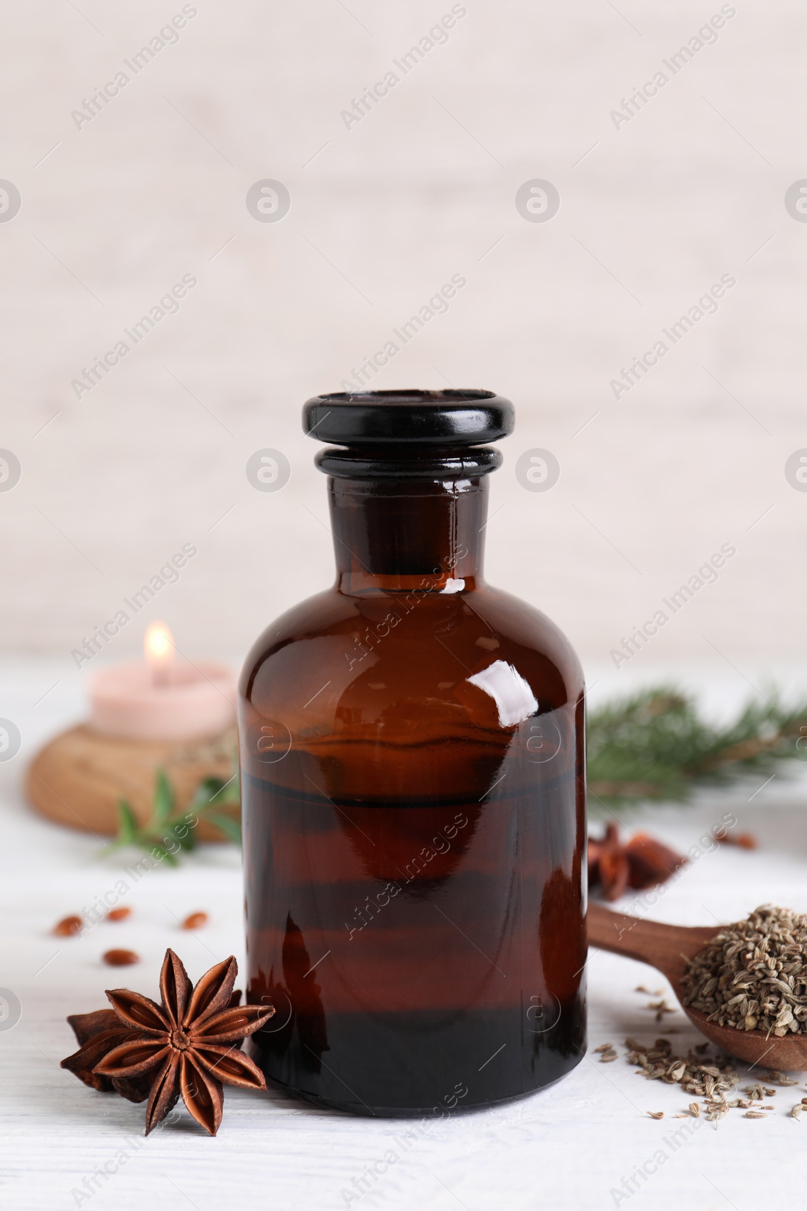 Photo of Anise essential oil and spice on white table