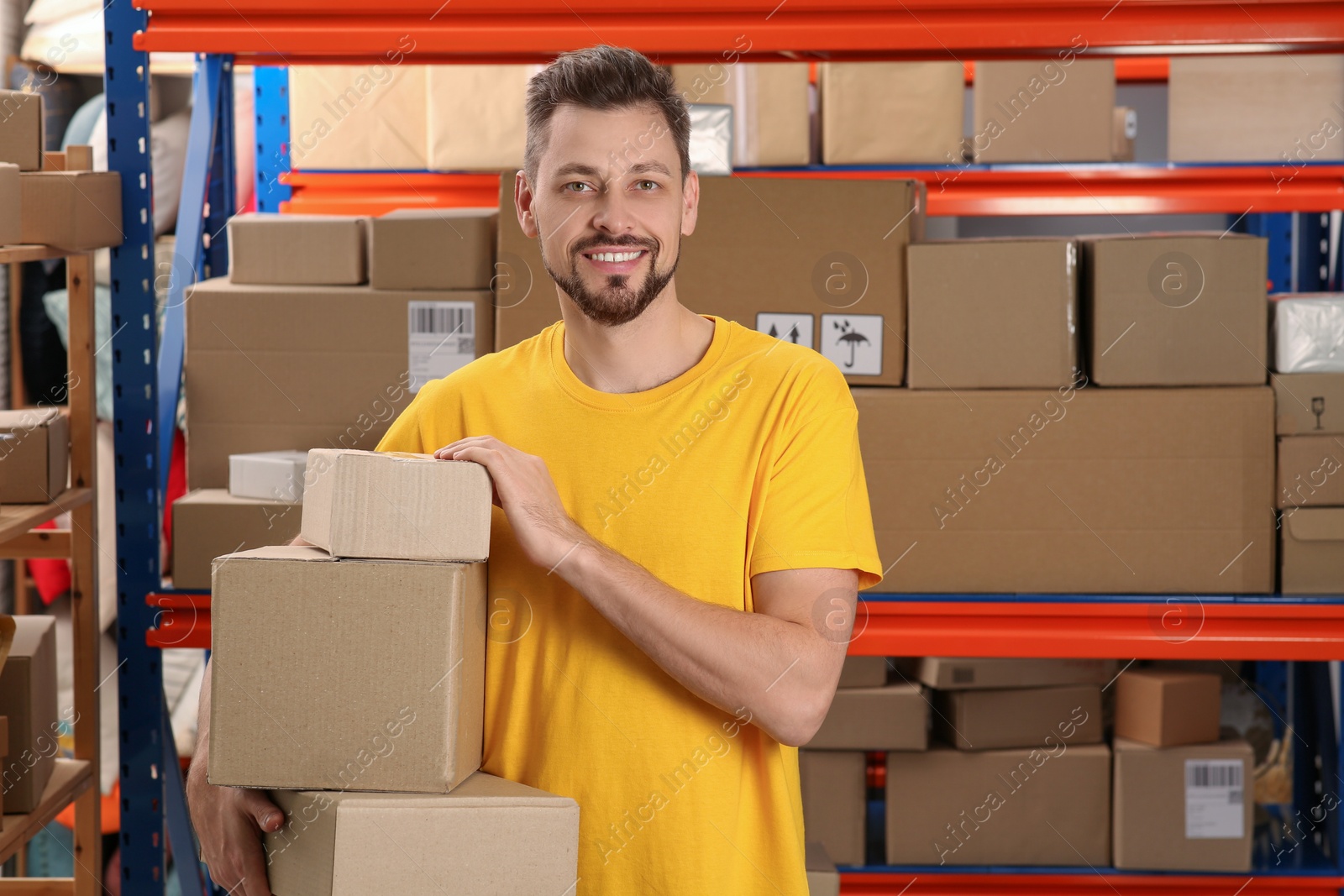 Photo of Post office worker with parcels near rack indoors