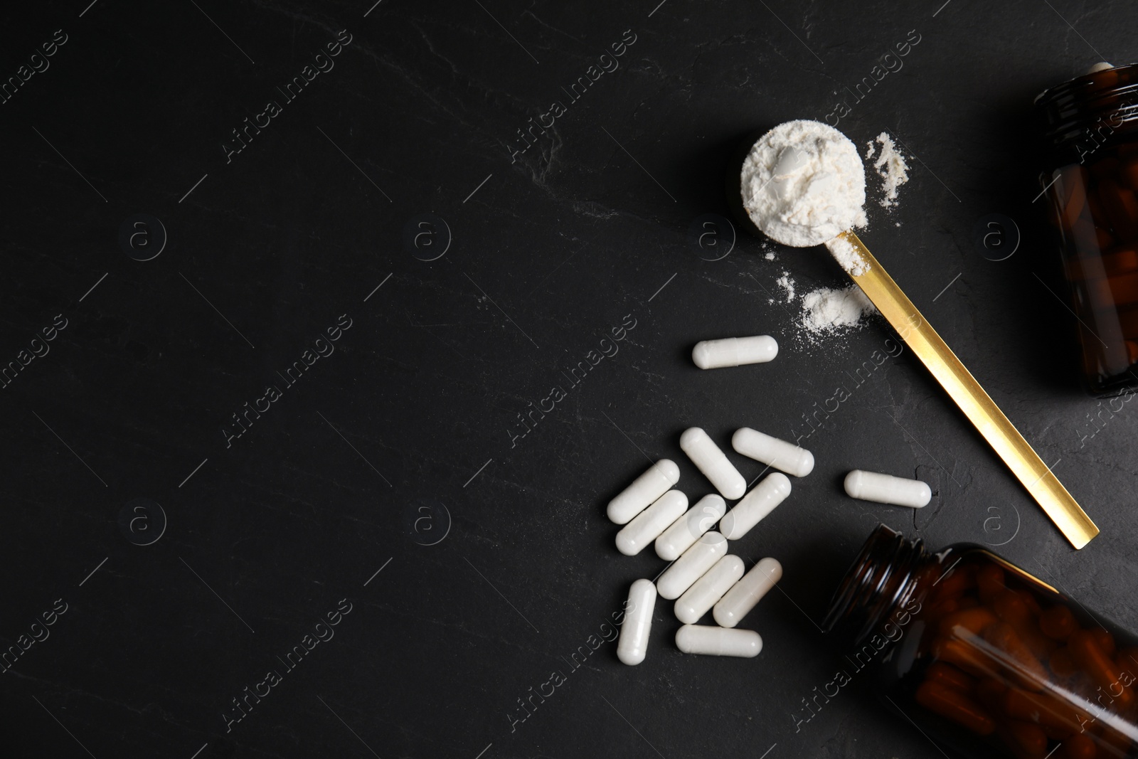Photo of Amino acids pills and powder on black table, flat lay. space for text