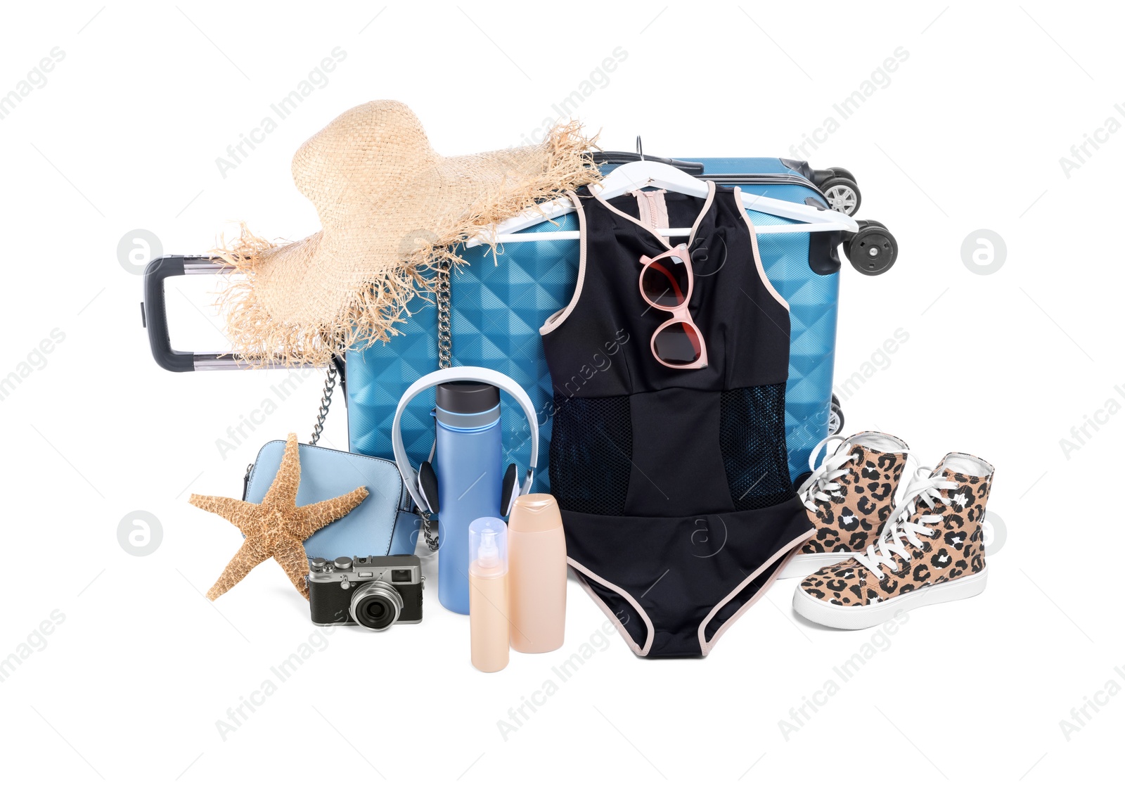 Photo of Suitcase with sneakers and different beach accessories isolated on white. Summer vacation