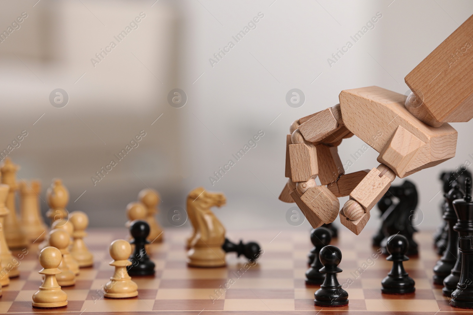 Photo of Wooden hand representing artificial intelligence. Robot moving chess piece on board against light background, closeup. Space for text