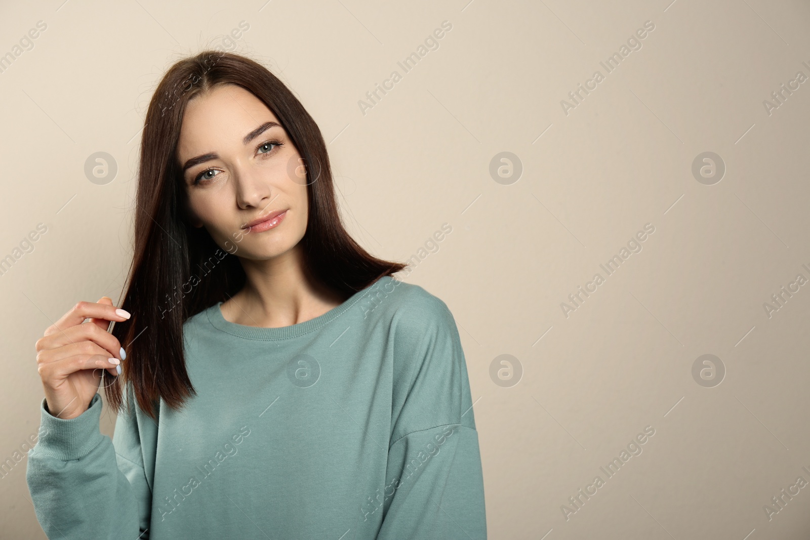 Photo of Portrait of pretty young woman with gorgeous chestnut hair on light background, space for text