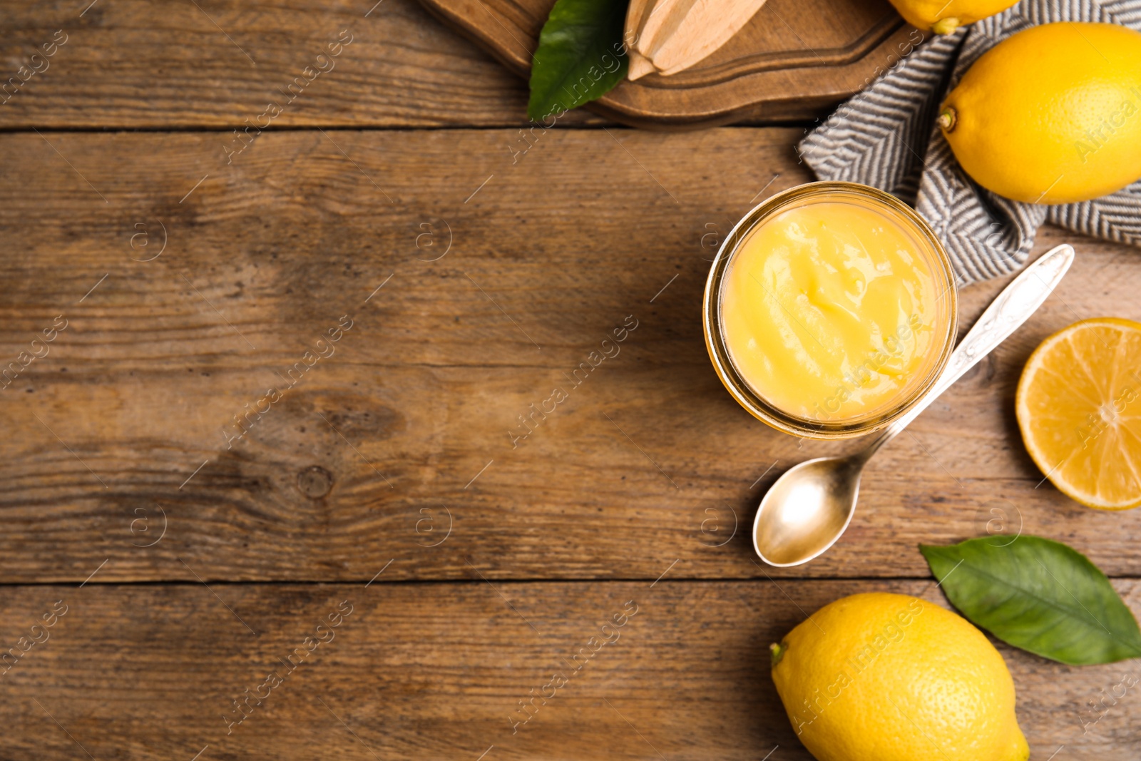 Photo of Delicious lemon curd and fresh fruits on wooden table, flat lay. Space for text
