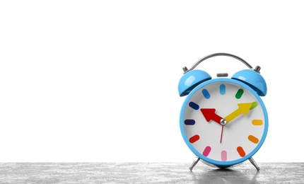 Alarm clock on table against white background. Time concept