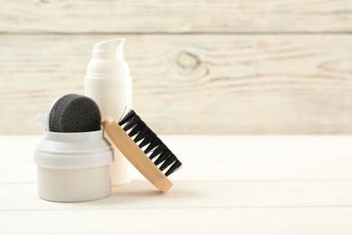 Photo of Composition with shoe care accessories on white wooden table, closeup. Space for text