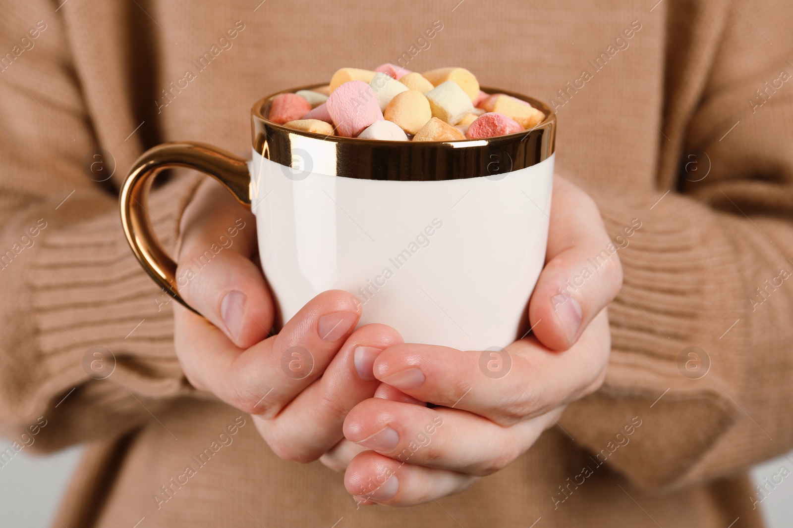 Photo of Woman holding cup of delicious hot chocolate with marshmallows, closeup