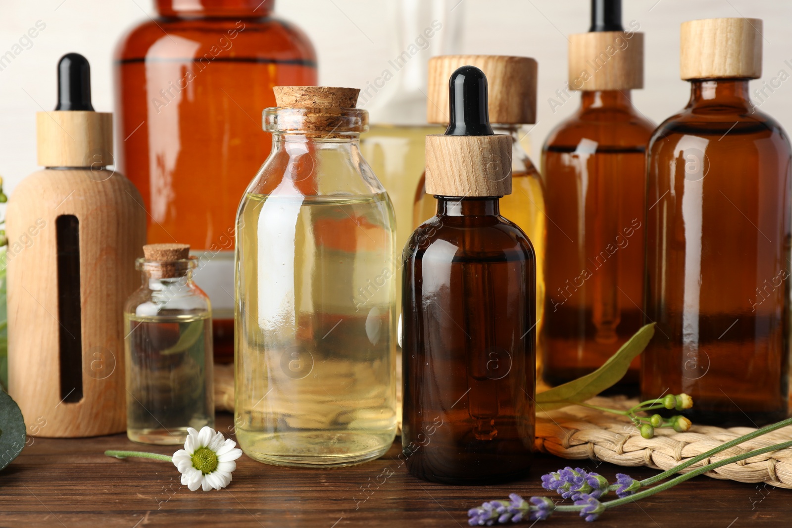 Photo of Aromatherapy. Different essential oils and flowers on wooden table