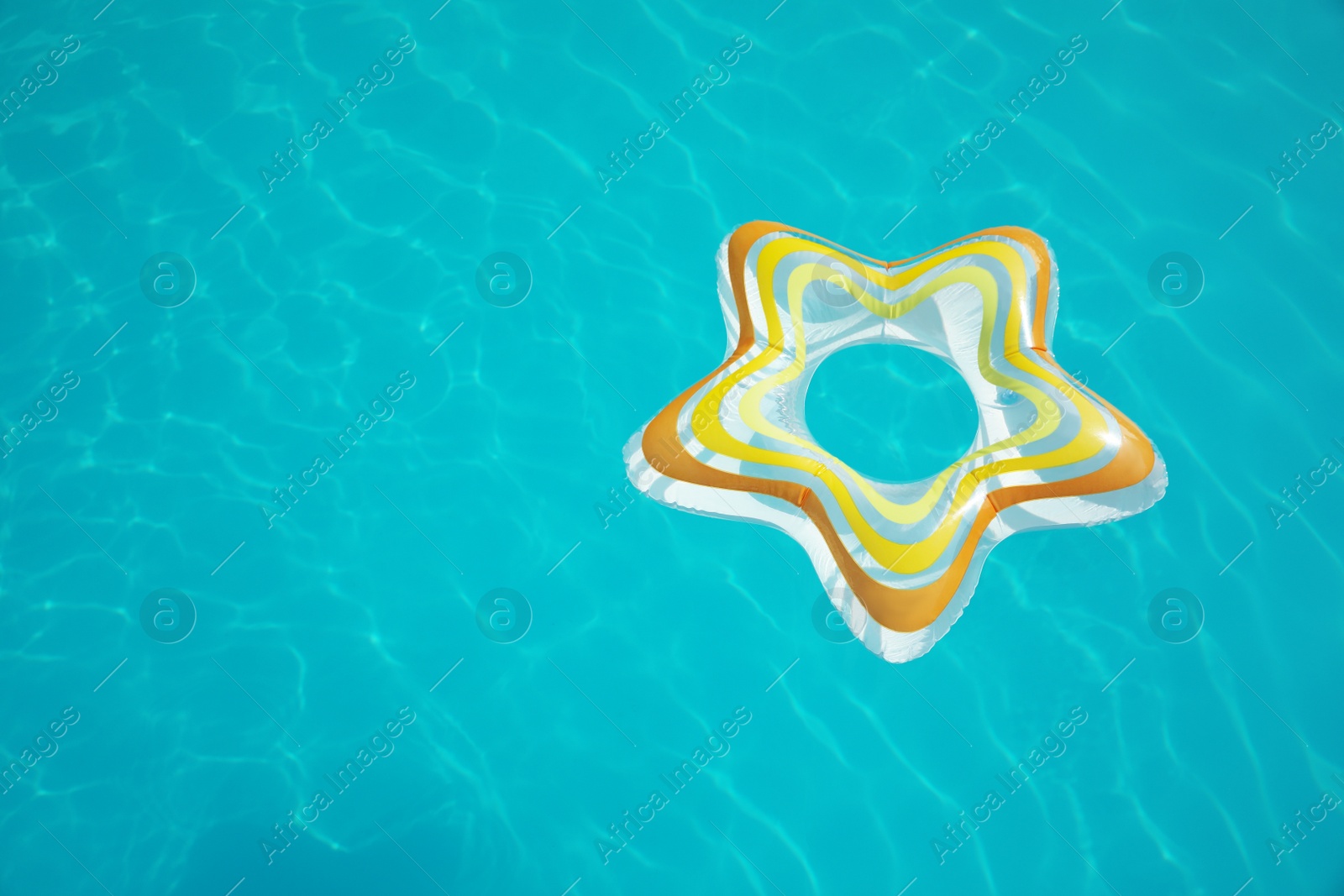 Photo of Star shaped inflatable ring floating in swimming pool on sunny day, above view. Space for text