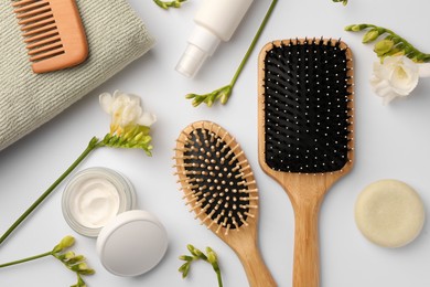 Photo of Flat lay composition with wooden hairbrushes and different cosmetic products on white background