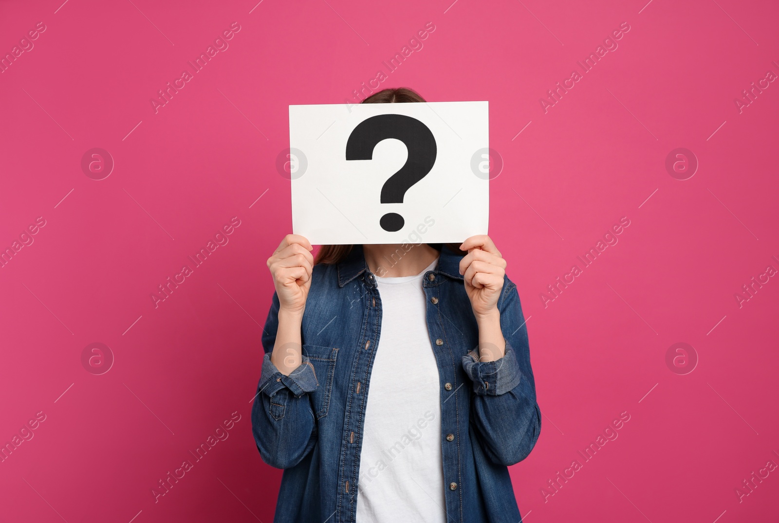 Photo of Woman holding question mark sign on pink background