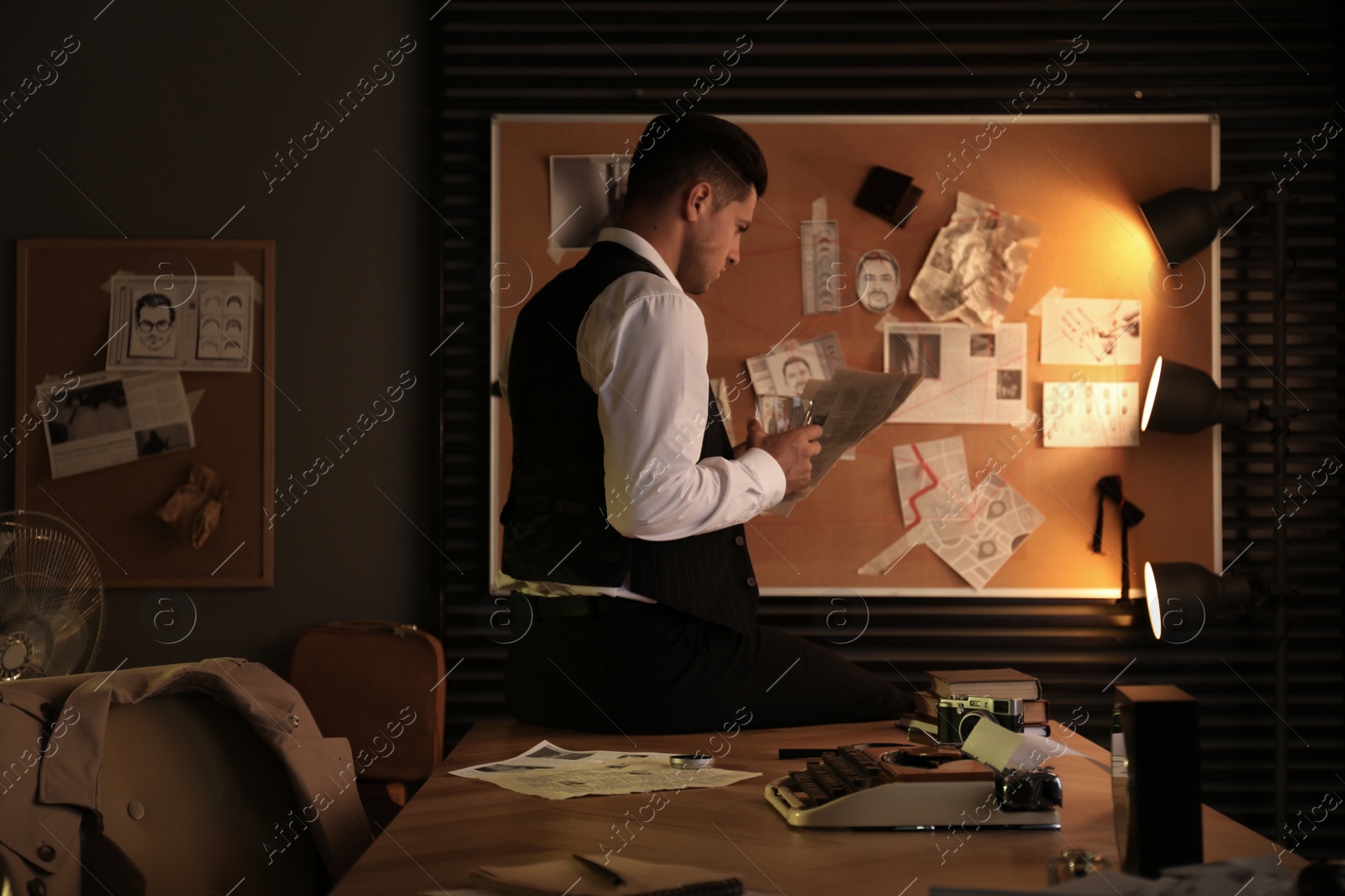 Photo of Old fashioned detective with documents near investigation board in office