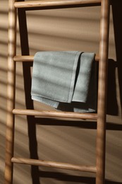Photo of Terry towel on wooden decorative ladder near beige wall