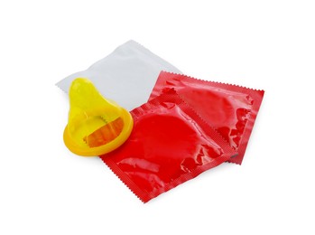 Packages and unpacked condoms isolated on white. Safe sex