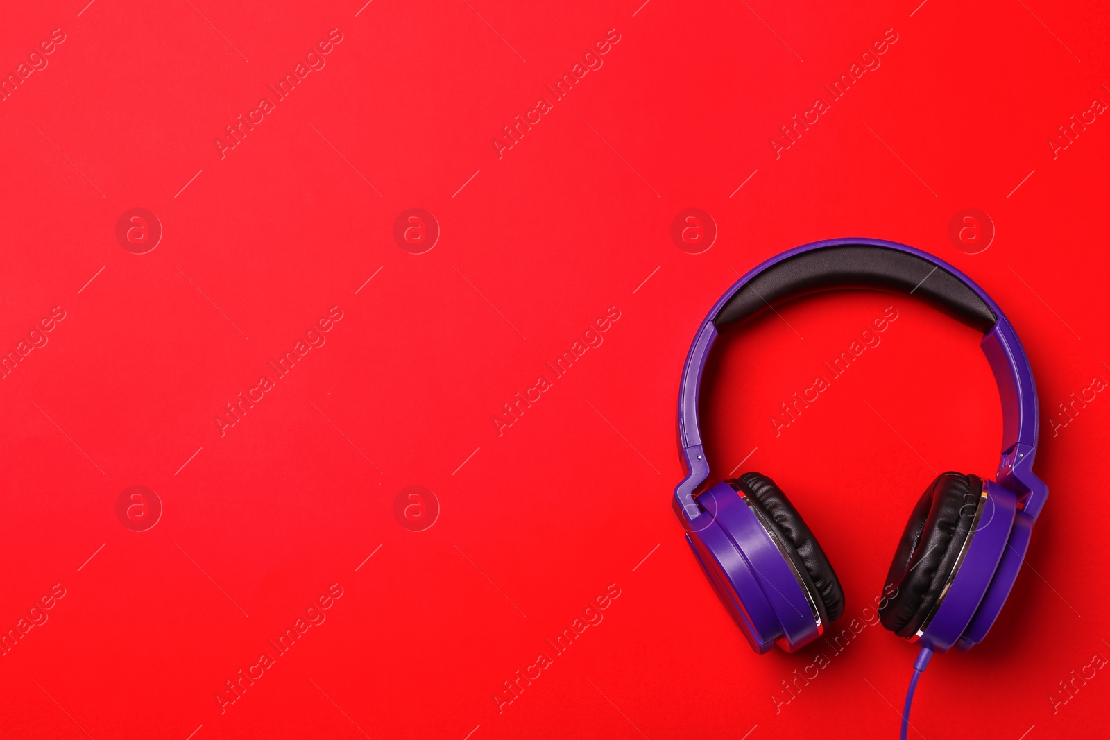 Photo of Stylish modern headphones on color background, top view. Space for text