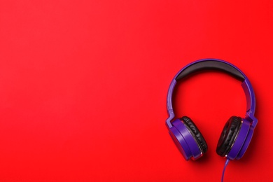 Stylish modern headphones on color background, top view. Space for text