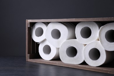 Photo of Toilet paper rolls in crate on wooden table