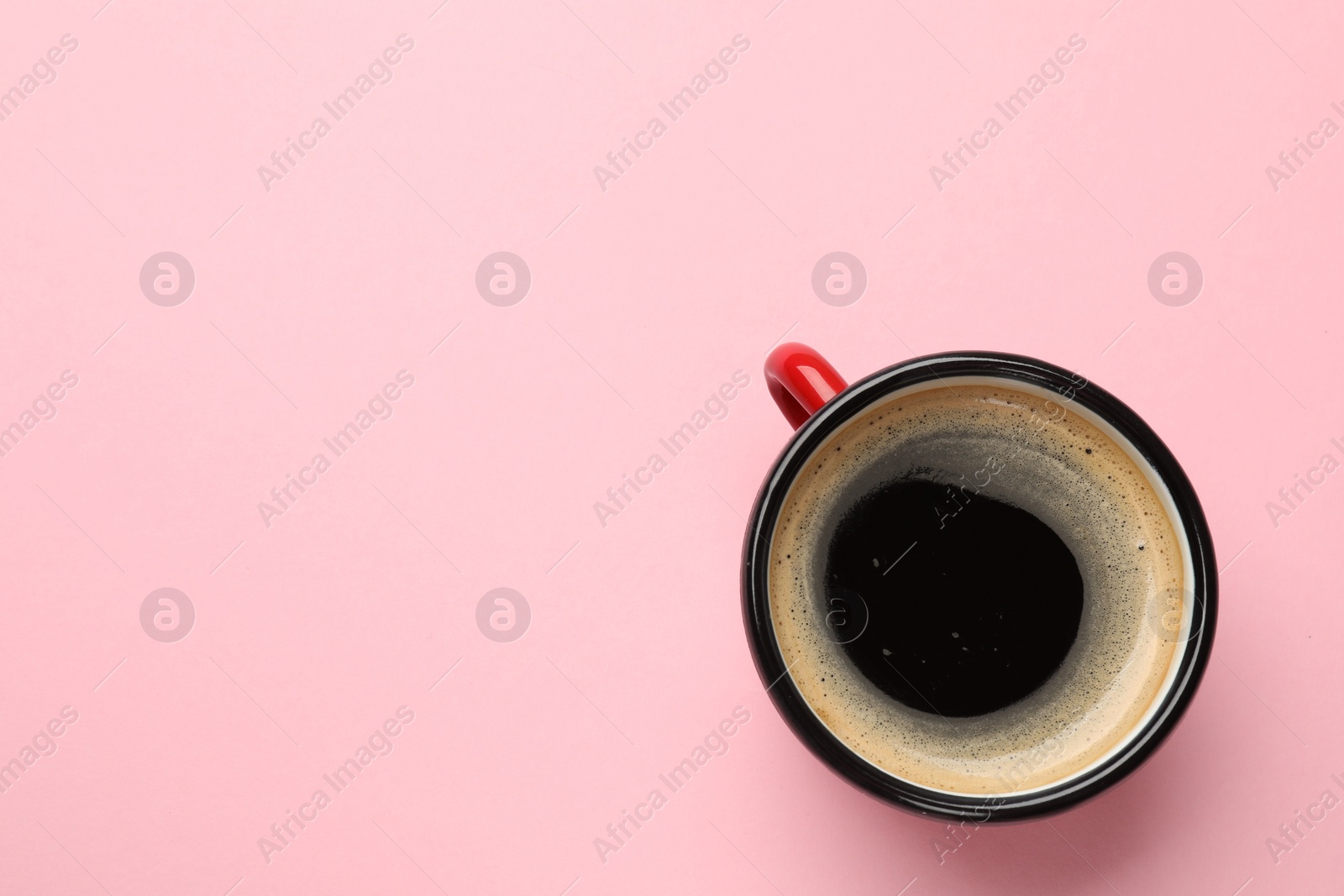 Photo of Fresh coffee in cup on pink background, top view. Space for text