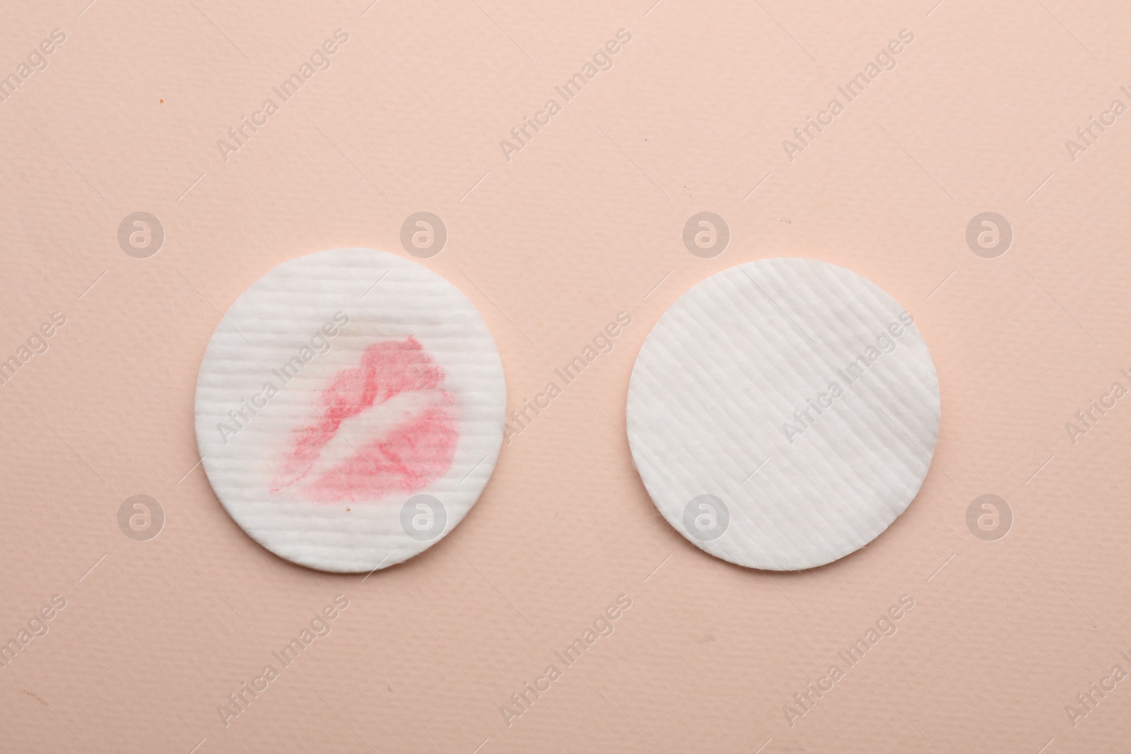 Photo of Clean and dirty cotton pads after removing makeup on beige background, flat lay