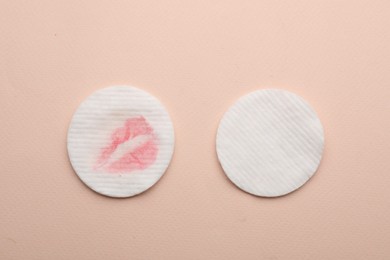 Clean and dirty cotton pads after removing makeup on beige background, flat lay