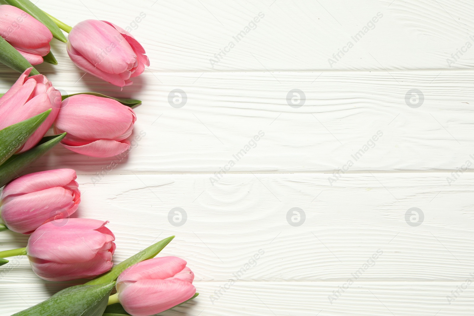 Photo of Happy Mother's Day. Beautiful pink tulips on white wooden table, flat lay. Space for text