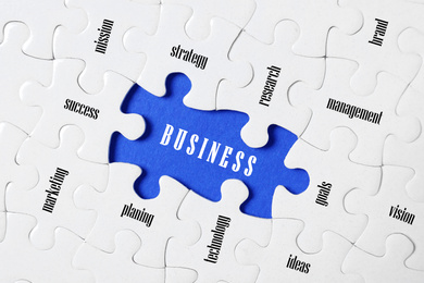 Image of Business concept. White puzzle pieces with different phrases on blue background, top view 