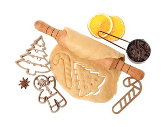 Photo of Christmas treat. Cookie cutters, dough and rolling pin on white background, top view