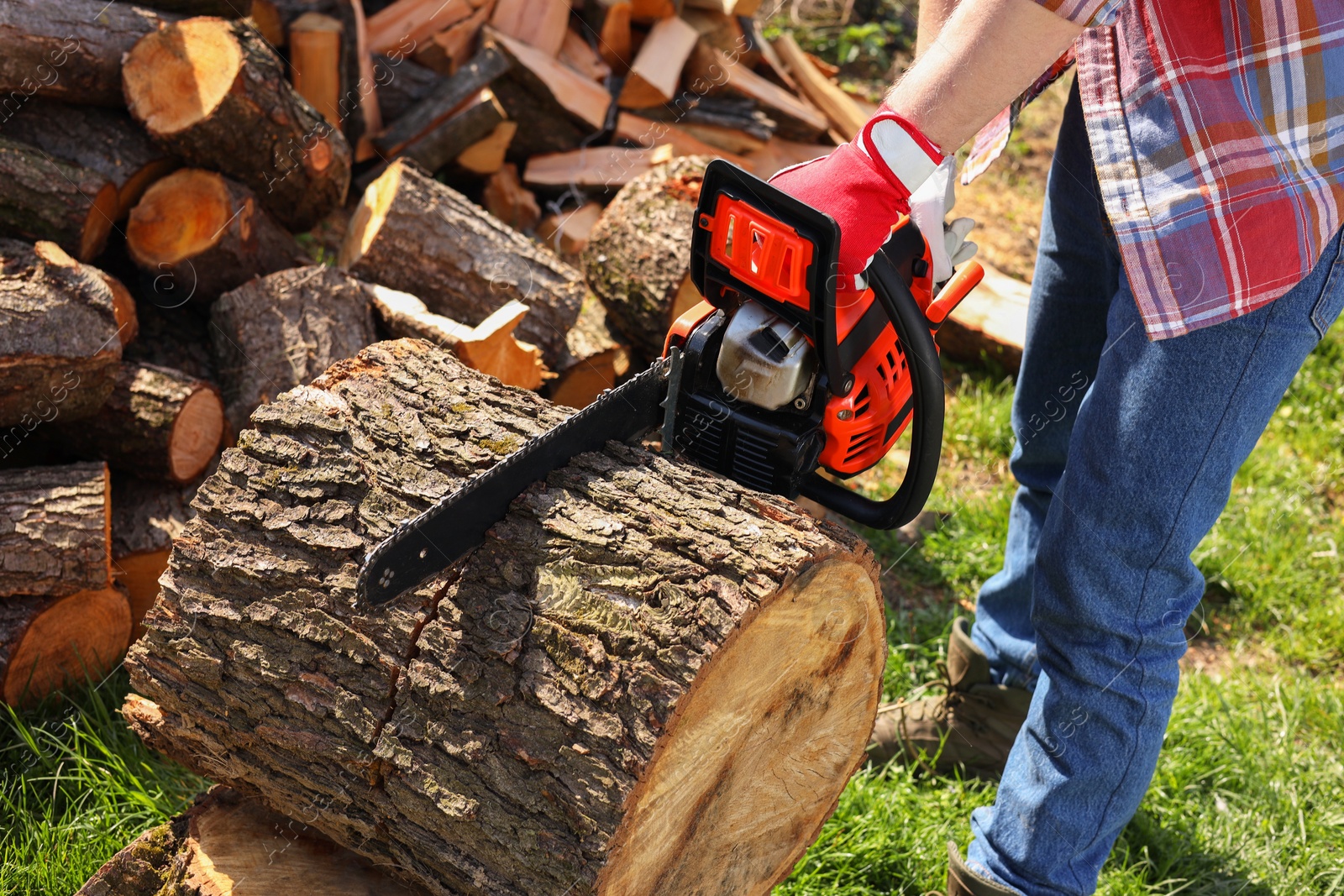 Photo of Man sawing wooden log on sunny day, closeup