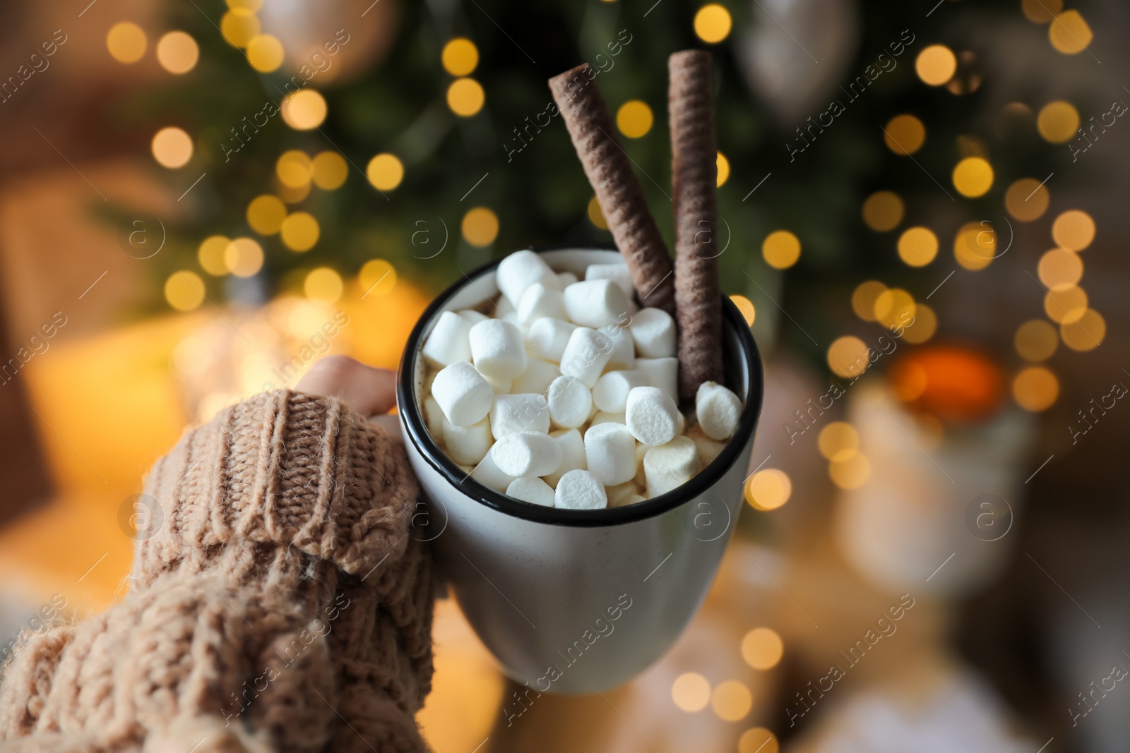 Photo of Woman with cup of cocoa indoors, closeup. Christmas mood