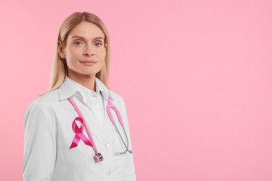 Photo of Doctor with pink ribbon and stethoscope on color background, space for text. Breast cancer awareness