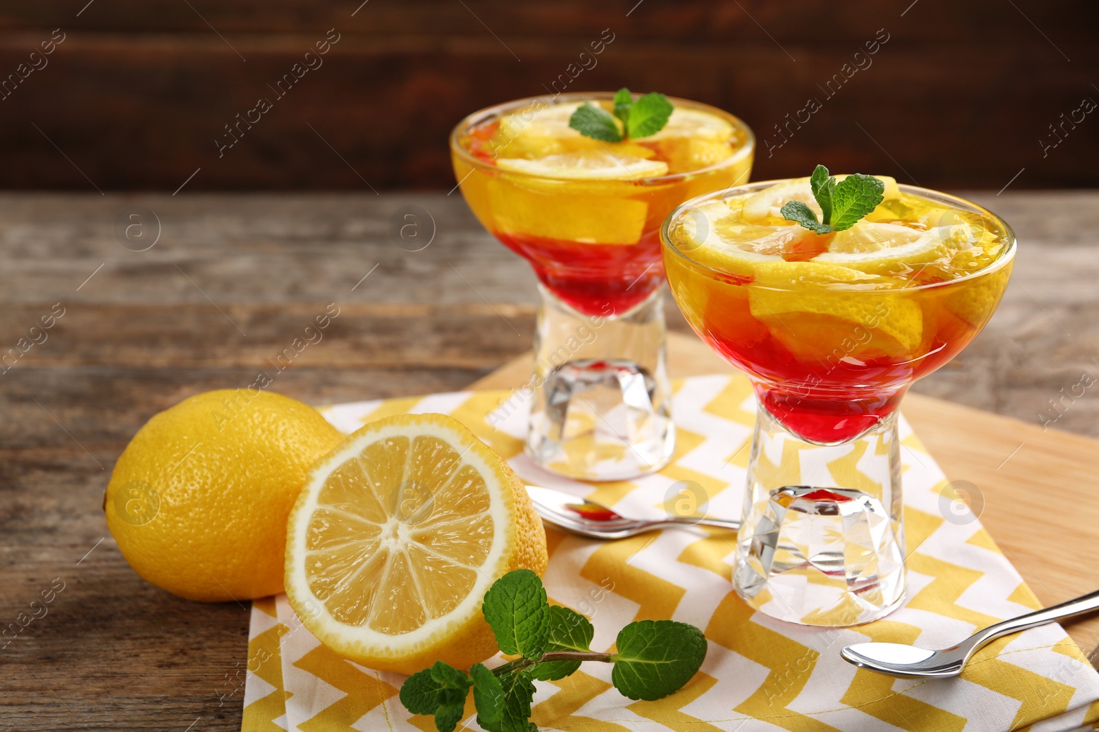 Photo of Dessert bowls of lemon jelly served on wooden table. Space for text