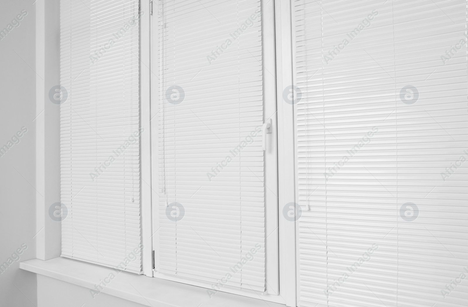 Photo of Stylish window with horizontal blinds in room