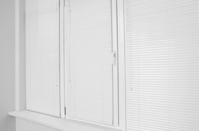 Stylish window with horizontal blinds in room