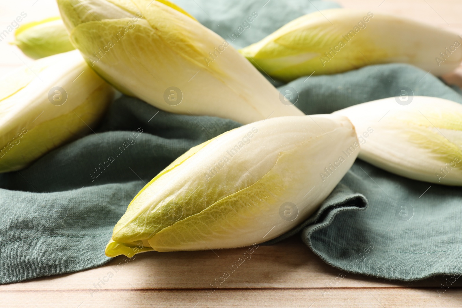 Photo of Raw ripe chicories on wooden table, closeup