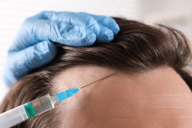 Photo of Trichologist giving injection to patient in clinic, closeup