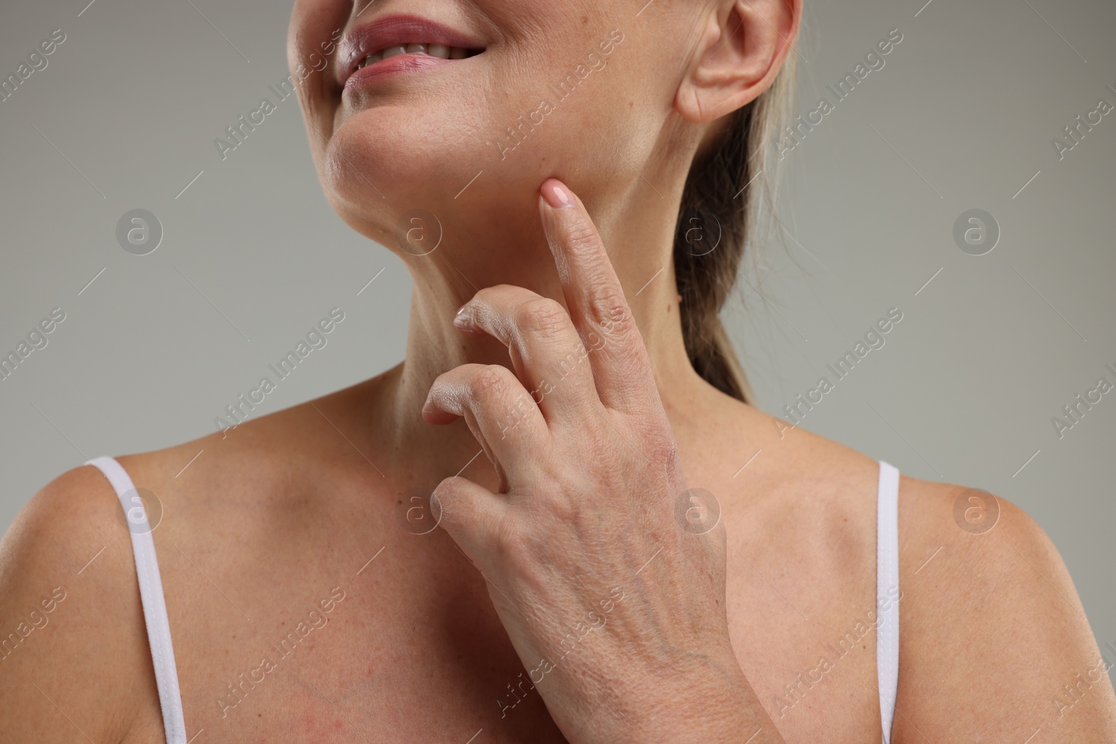 Photo of Mature woman with healthy skin on grey background, closeup