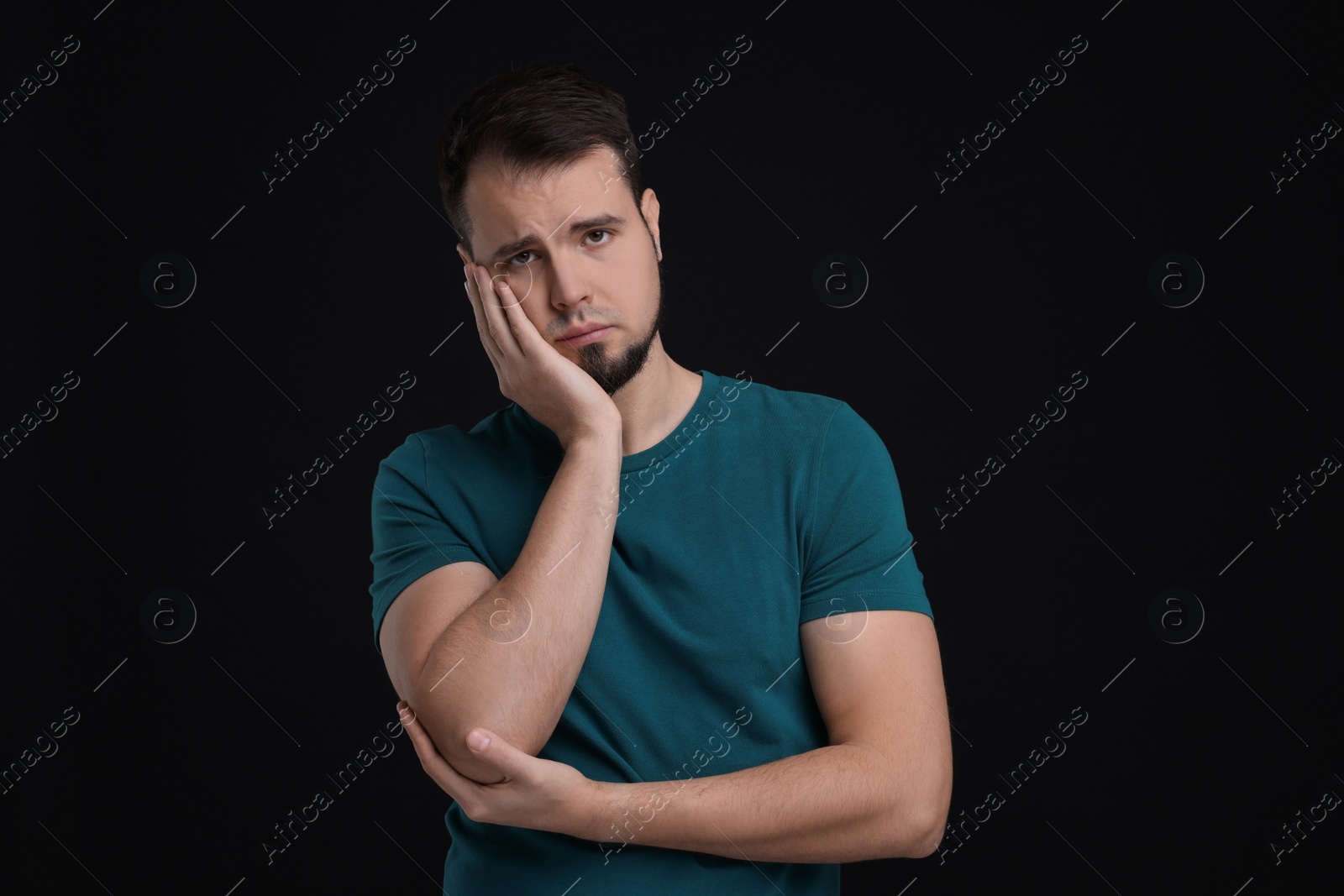 Photo of Portrait of sad man on black background