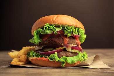 Photo of Tasty burger with vegetables, patties and lettuce served on wooden table, closeup