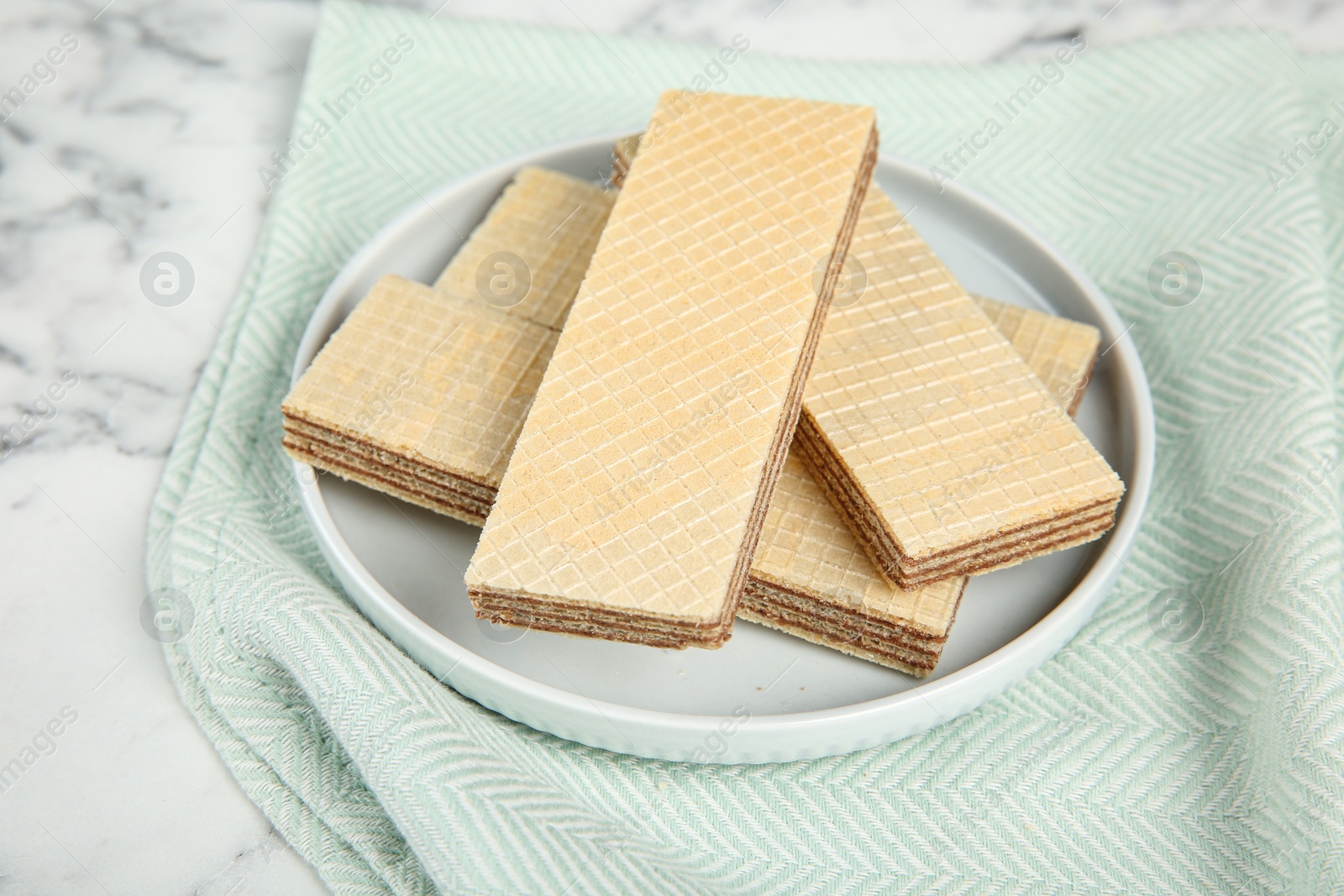 Photo of Plate of delicious wafers on marble background