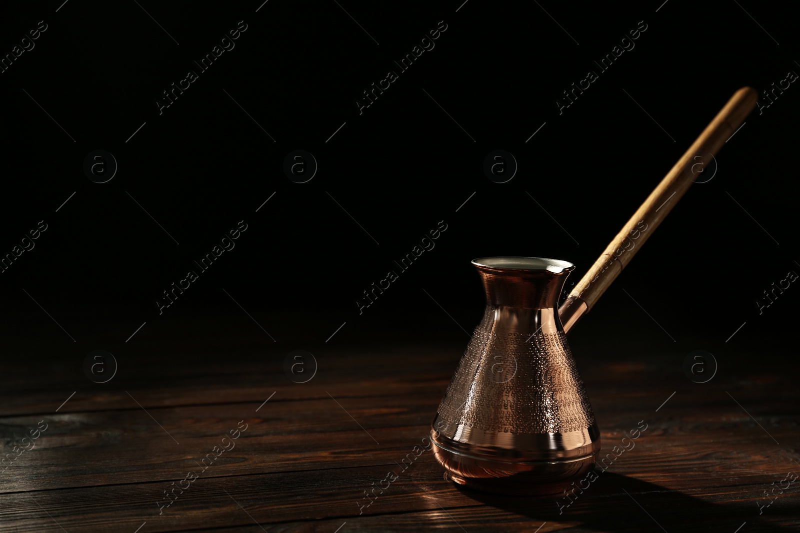 Photo of Beautiful copper turkish coffee pot on wooden table. Space for text