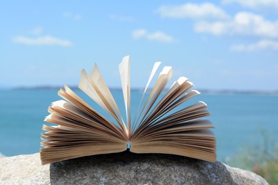 Photo of Open book near sea on summer day