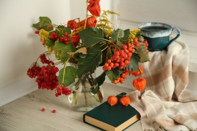 Beautiful autumn composition with cup of drink and book indoors