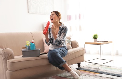 Photo of Happy woman having fun while cleaning room