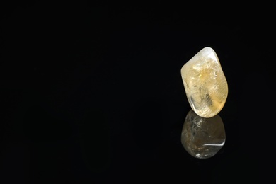 Beautiful citrine quartz gemstone on black background. Space for text